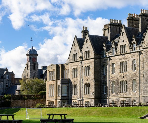 edificio principal grande, cesped y mesas de picnic enfrente en el curso escolar en inglaterra en St. Leonards School