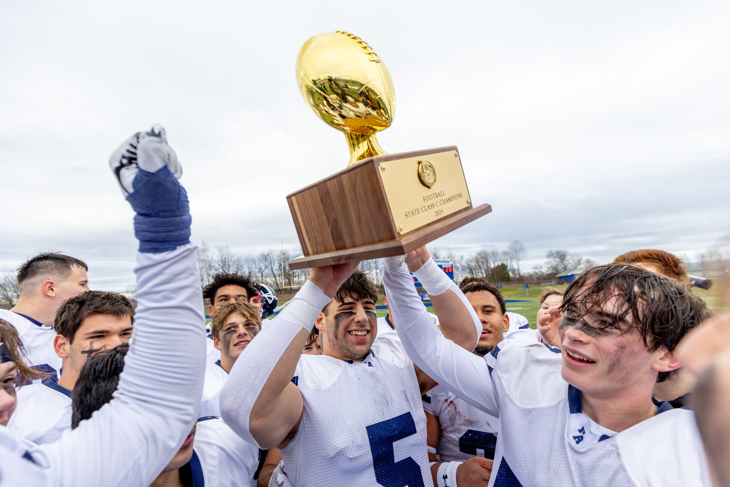 Equipo de estudiantes celebrando campeonato de fútbol americano, parte de la experiencia deportiva en un semestre en Estados Unidos.