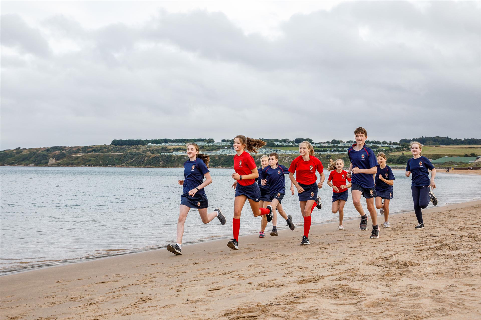 Estudiantes realizando actividades deportivas en la playa como parte de un trimestre escolar en Inglaterra.